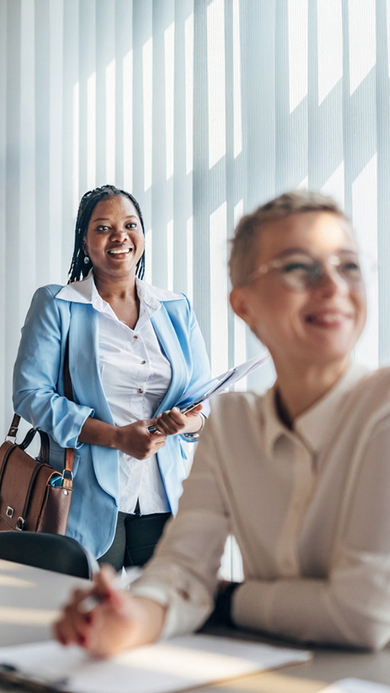 Two business people smiling in a modern and bright room