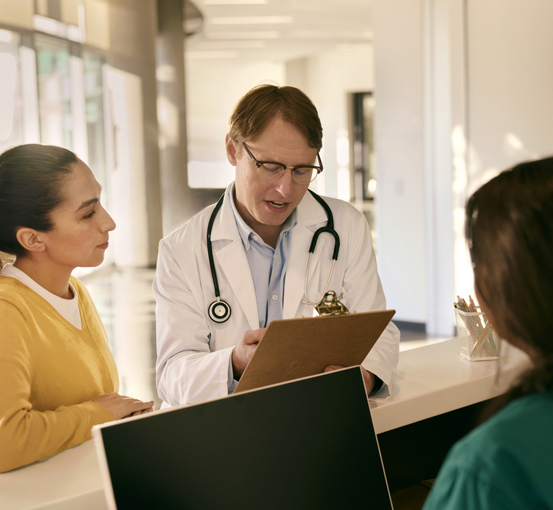 Doctor consulting with a patient at reception desk