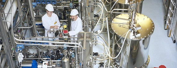 Two engineers are examining production equipment.