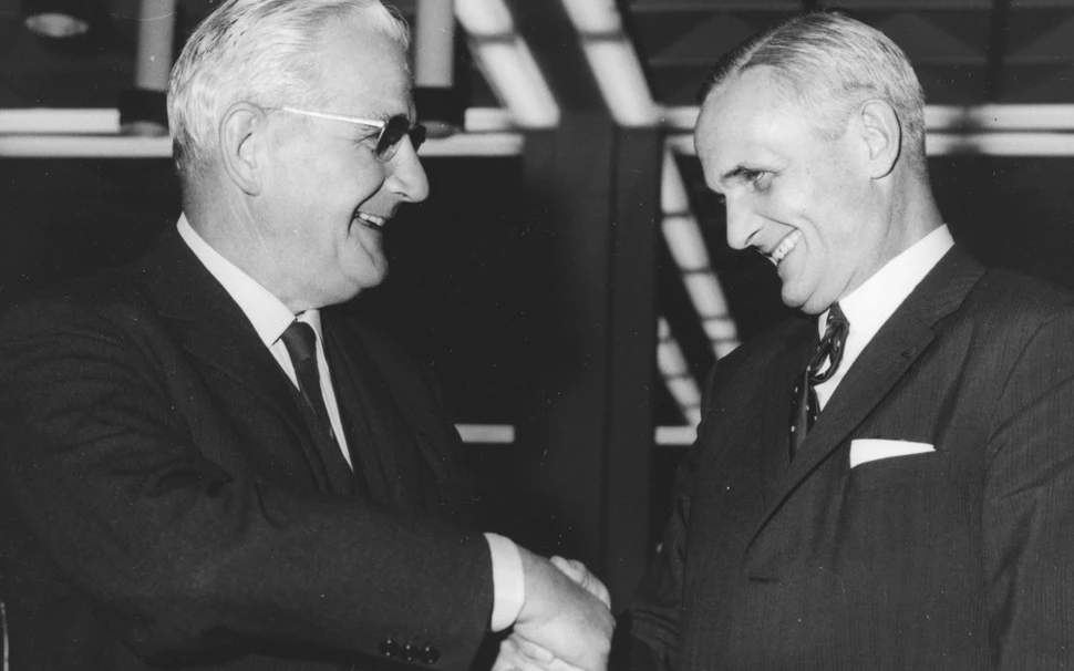 Presidentes da Geigy e da CIBA apertam as mãos para comemorar a fusão