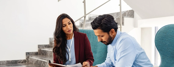 A female manager talking with her co-worker in a corporate lobby