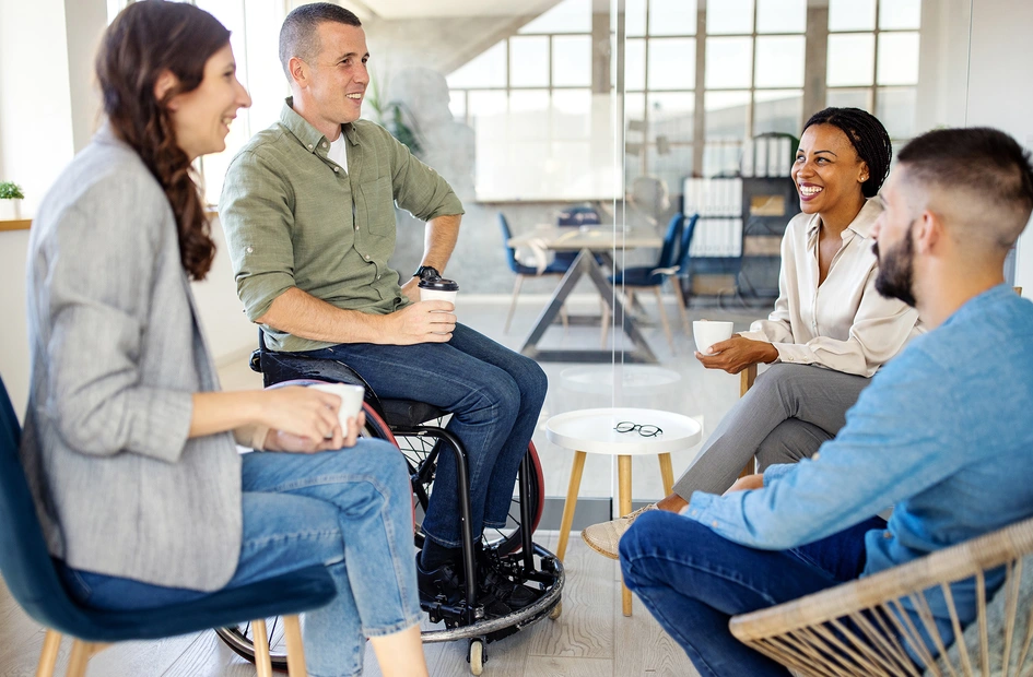 Group of four business people discussing and laughing