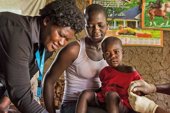 Nurse visits child with malaria in Kenya