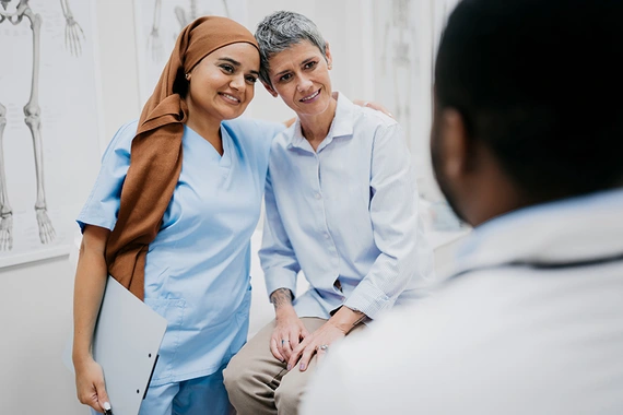 A nurse and patient engaged in a hug