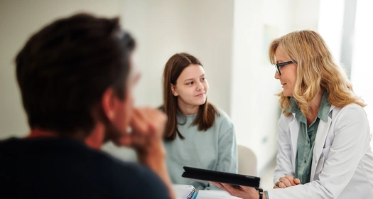 Pediatrician talking with a young teenager in the office