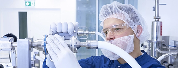 A Novartis production specialist connects tubes in a manufacturing plant 