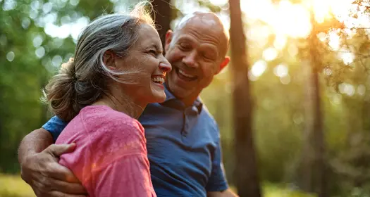Two people embracing in a wooded area