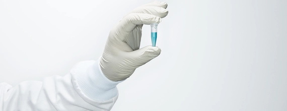 Gloved hand holding vial