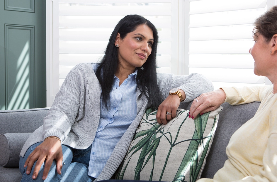 Women talking while sitting on sofa